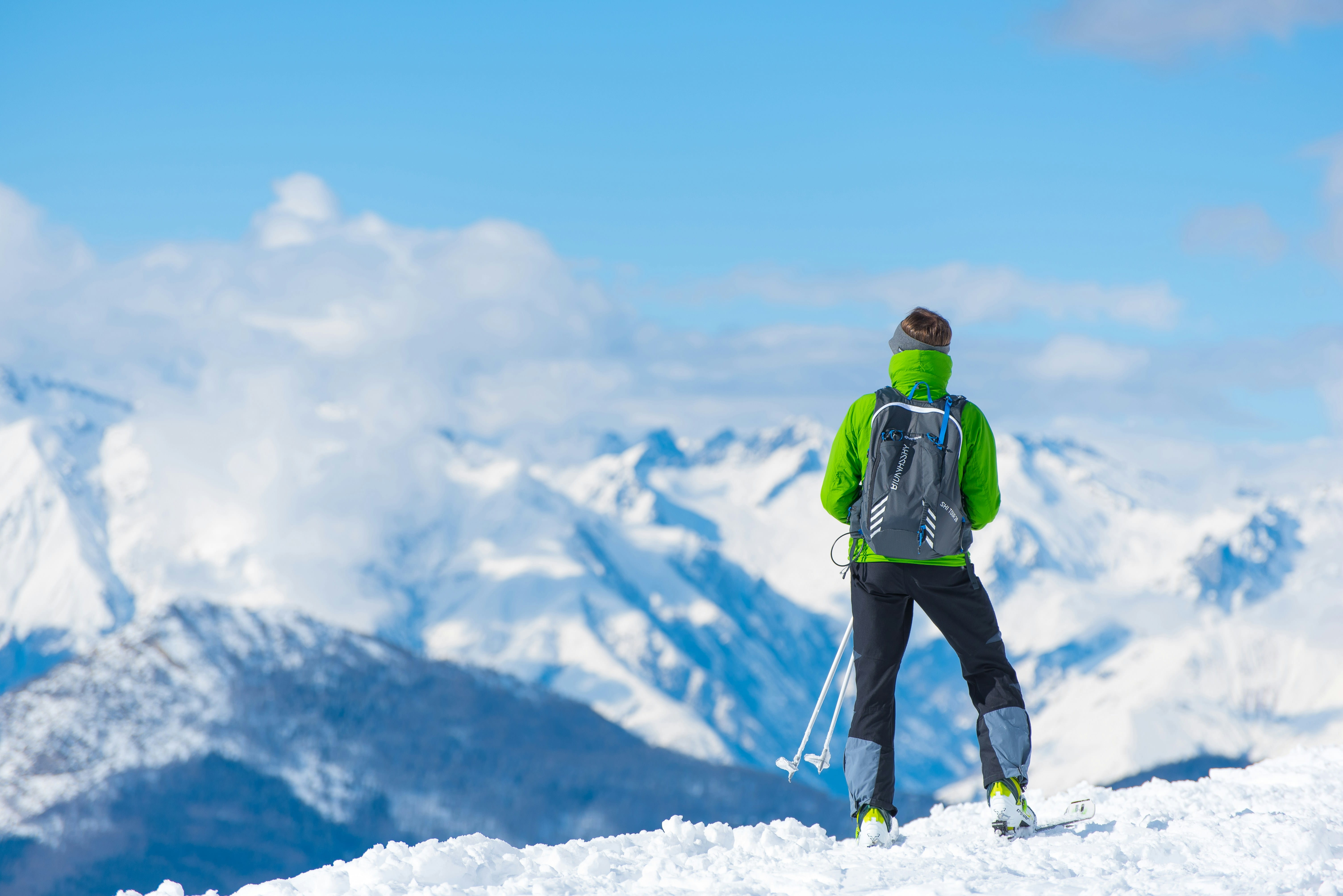 Man with ski poles looking out across mountain range image